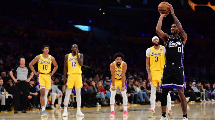 Lakers players watch as Kings’ Malik Monk attempts a free throw.